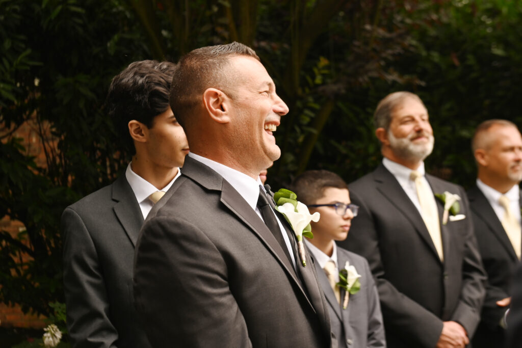 Groom laughing during Westbury Manor wedding reception Long Island