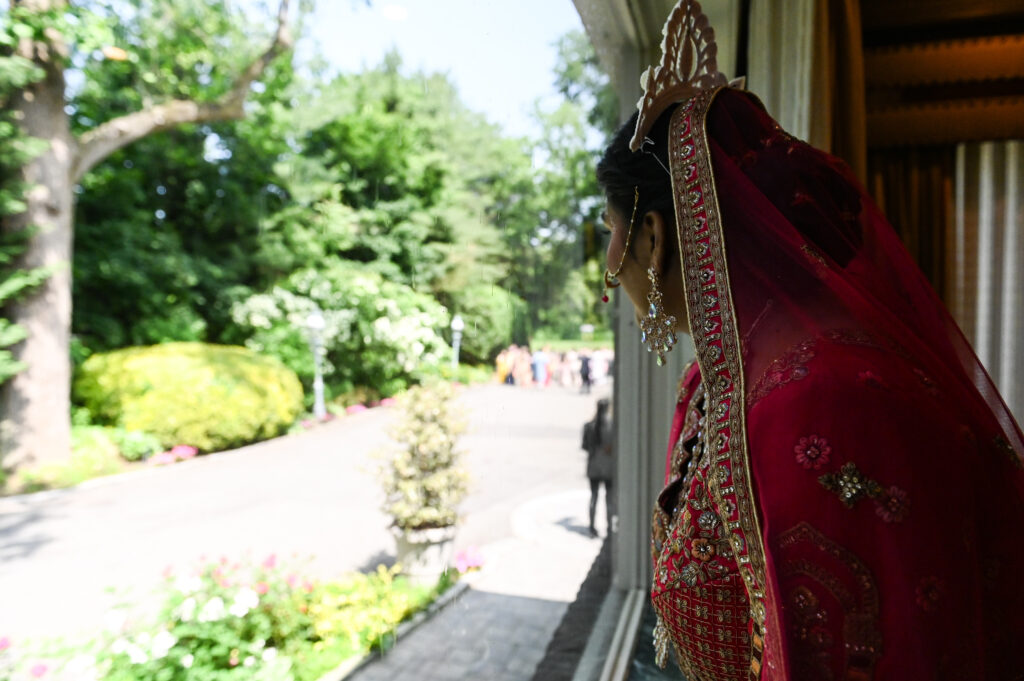 Bride walking along garden pathway at Westbury Manor Long Island wedding venue