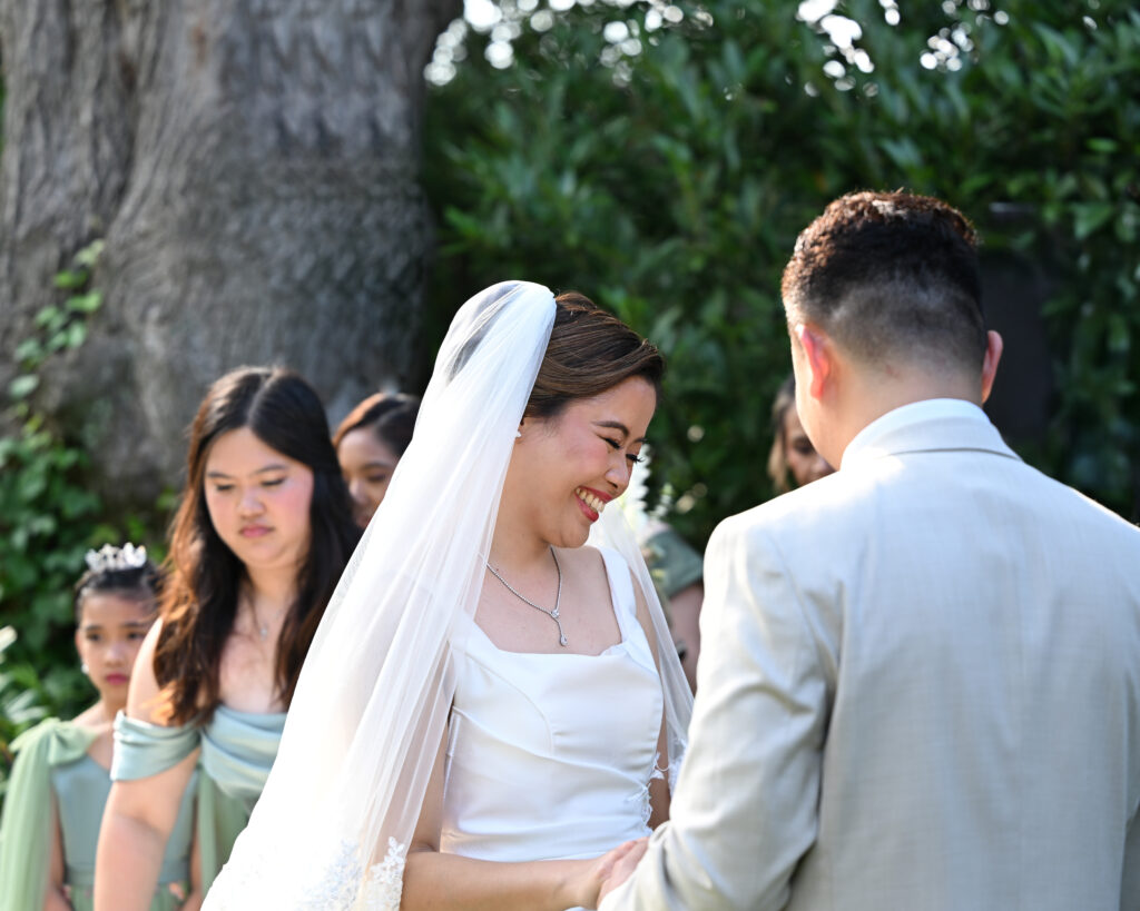 Bride and groom exchanging rings in Westbury Manor gardens Long Island