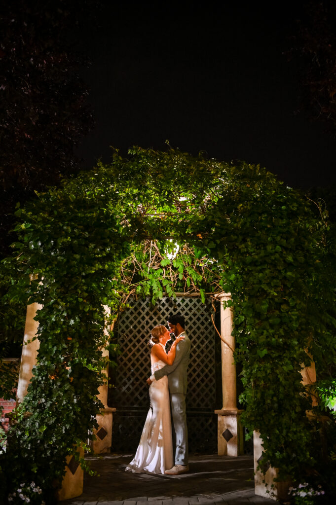 Bride and groom under illuminated garden arch at Westbury Manor Long Island wedding