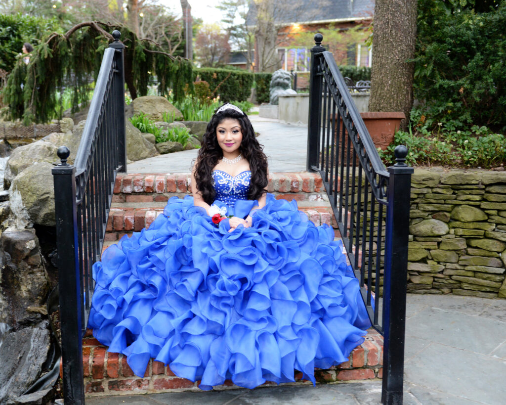 Girl in blue quinceañera gown on steps at Westbury Manor Long Island