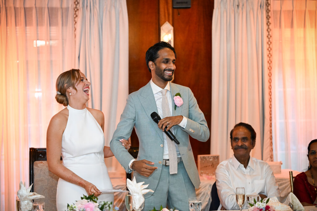 Bride and groom laughing during wedding reception speech at Westbury Manor