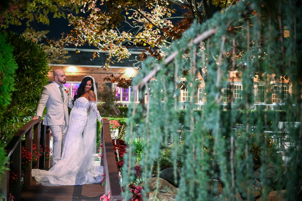 Bride walking under decorative greenery at Westbury Manor Long Island