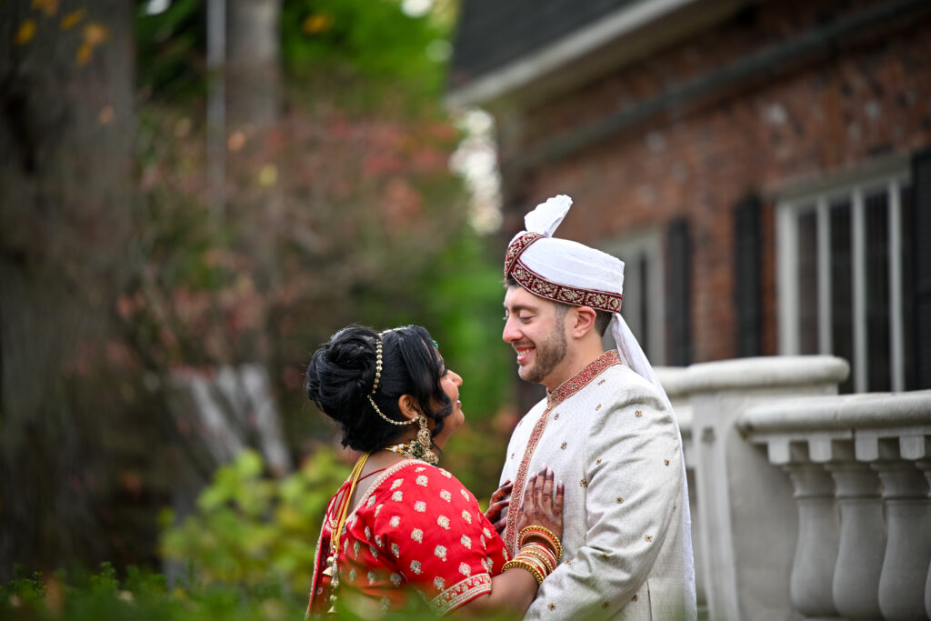 South Asian bride and groom near brick exterior at Westbury Manor Long Island