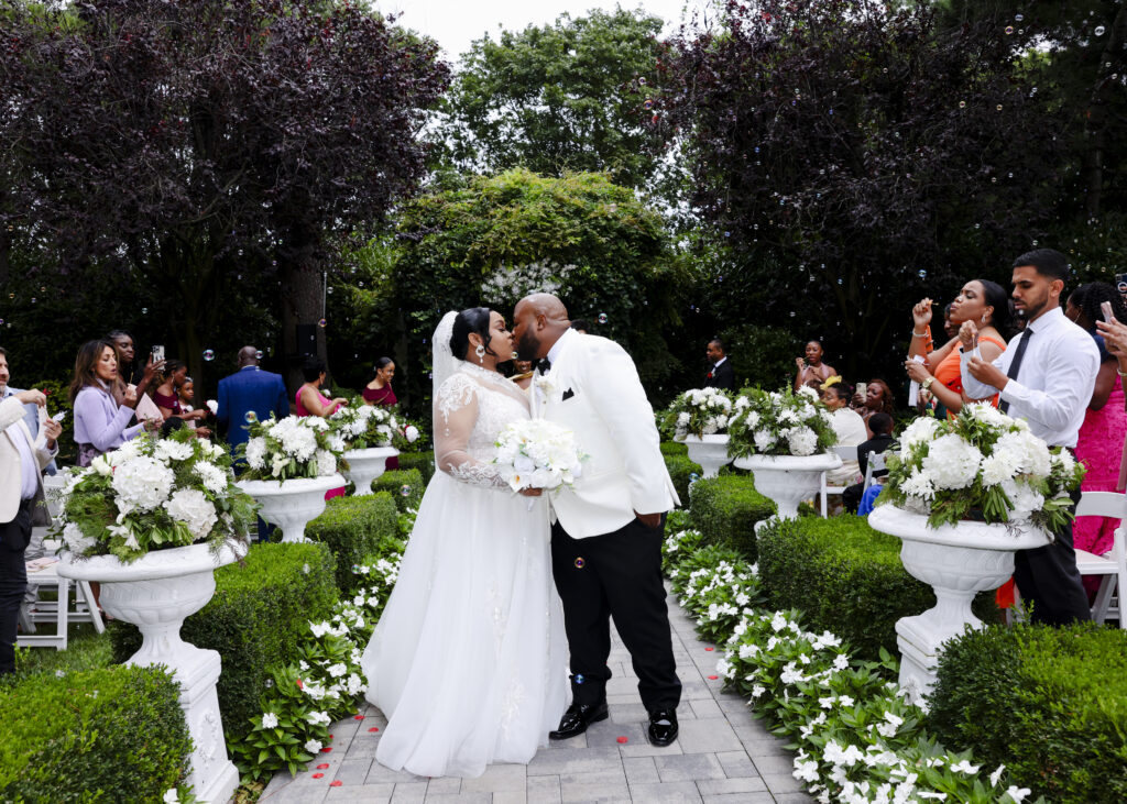 Bride and groom kissing after ceremony in Westbury Manor garden Long Island