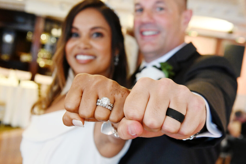 Bride and groom showing wedding rings at Westbury Manor Long Island wedding